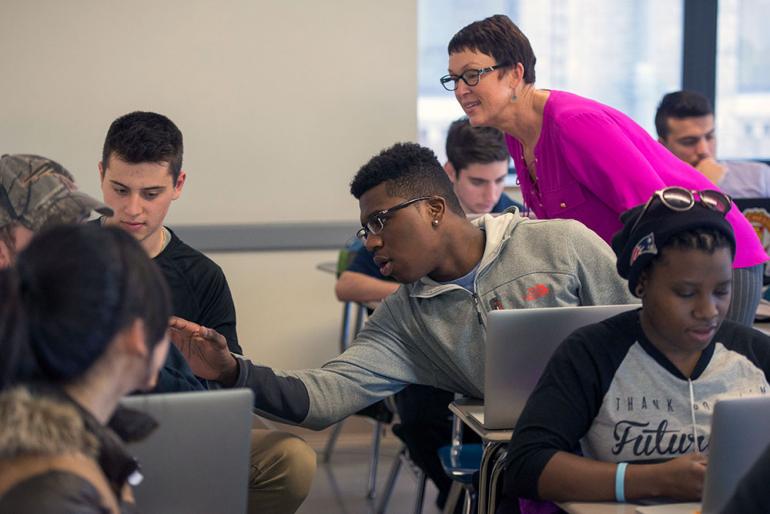 Cindy Stevens works with students in classroom.