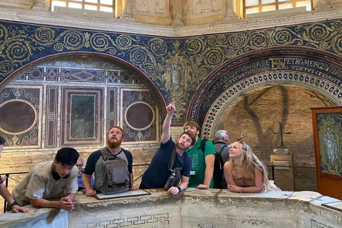 Architecture and Design students pointing to architectural details in a ruin abroad.