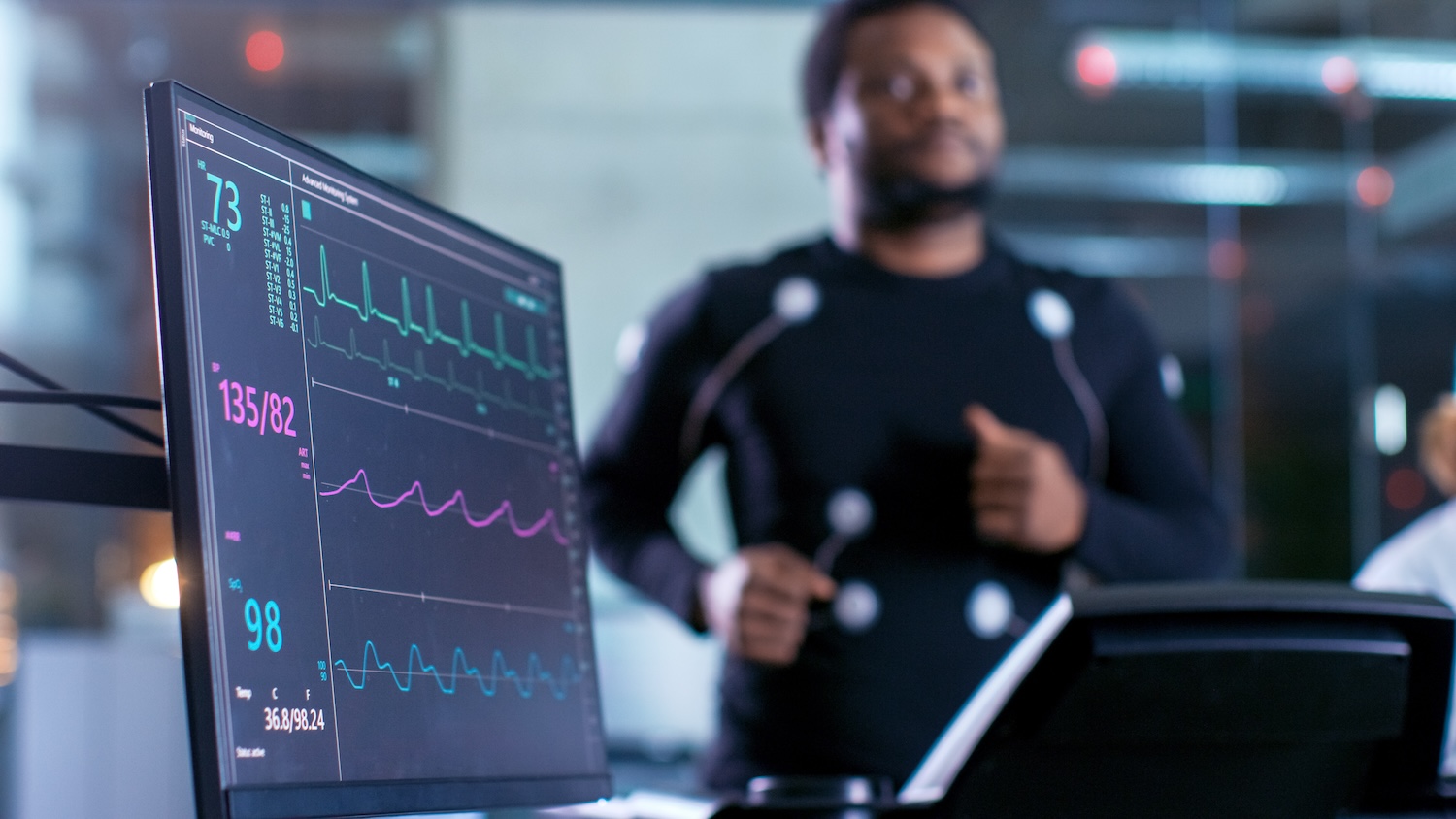 monitor showing vital information while a man runs on treadmill