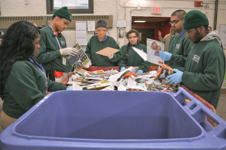 A diverse group of students sorting recycling