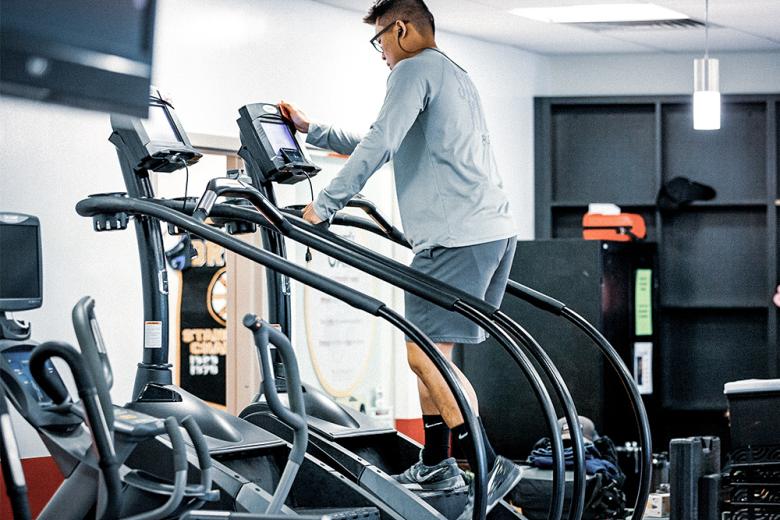 A man uses an elliptical machine in the Beatty Hall gym