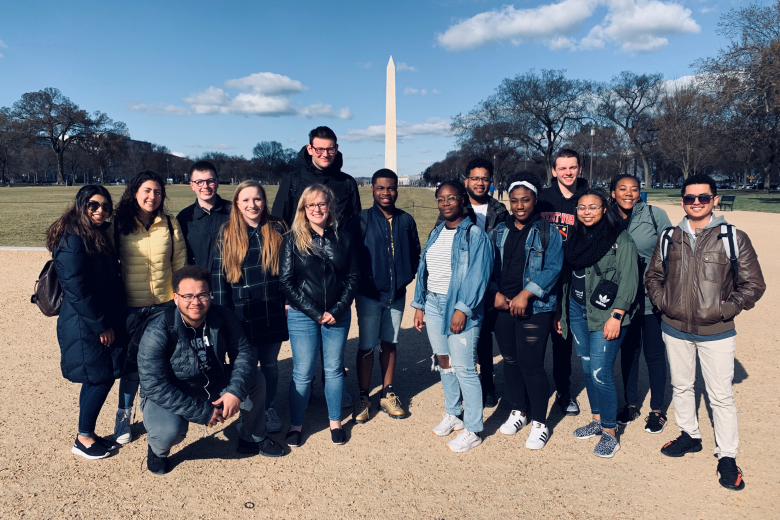 students standing outside in front of a monument 