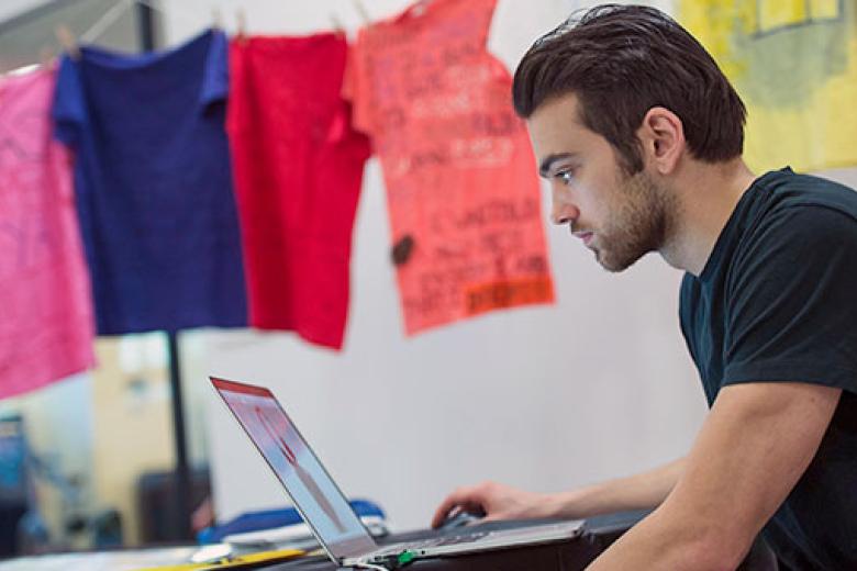 A male student works on his laptop