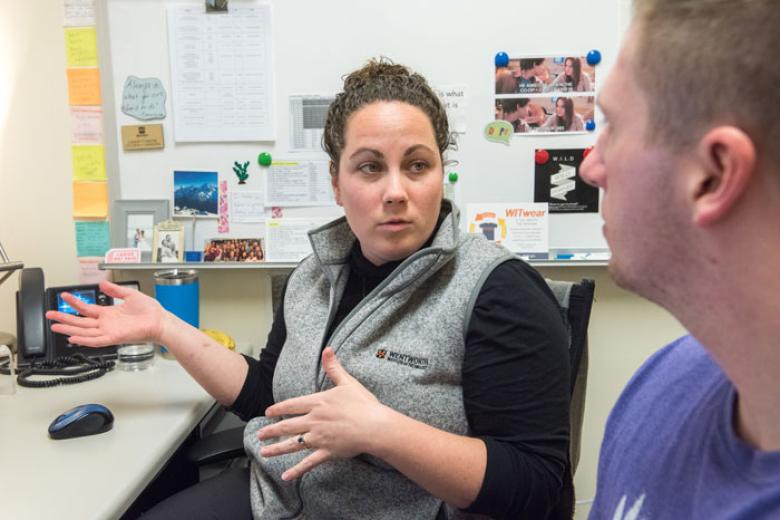 A female advisor speaks with a male student