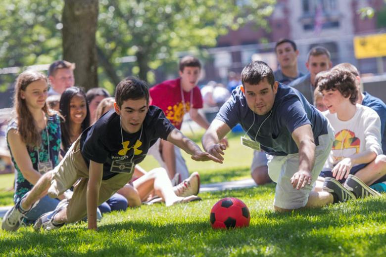 A group of students dive for a ball