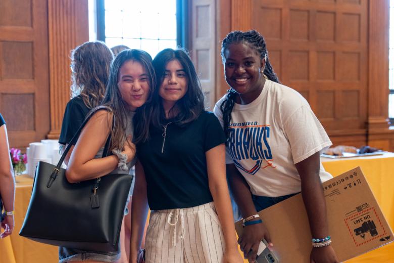 Three women students from the Honors Cohort smile and pose after the Honors Cohort lunch