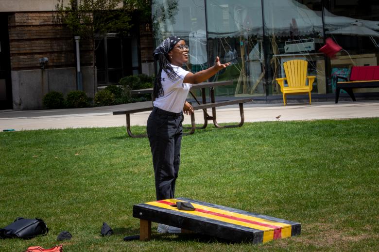 a woman plays a game with a bean bag