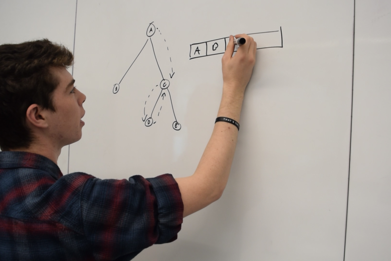 student writing on a whiteboard