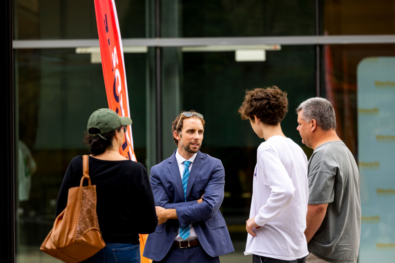 Four people stand outside talking to each other