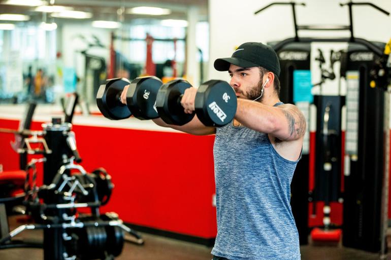 wentworth student lifting dumbbells in fitness center